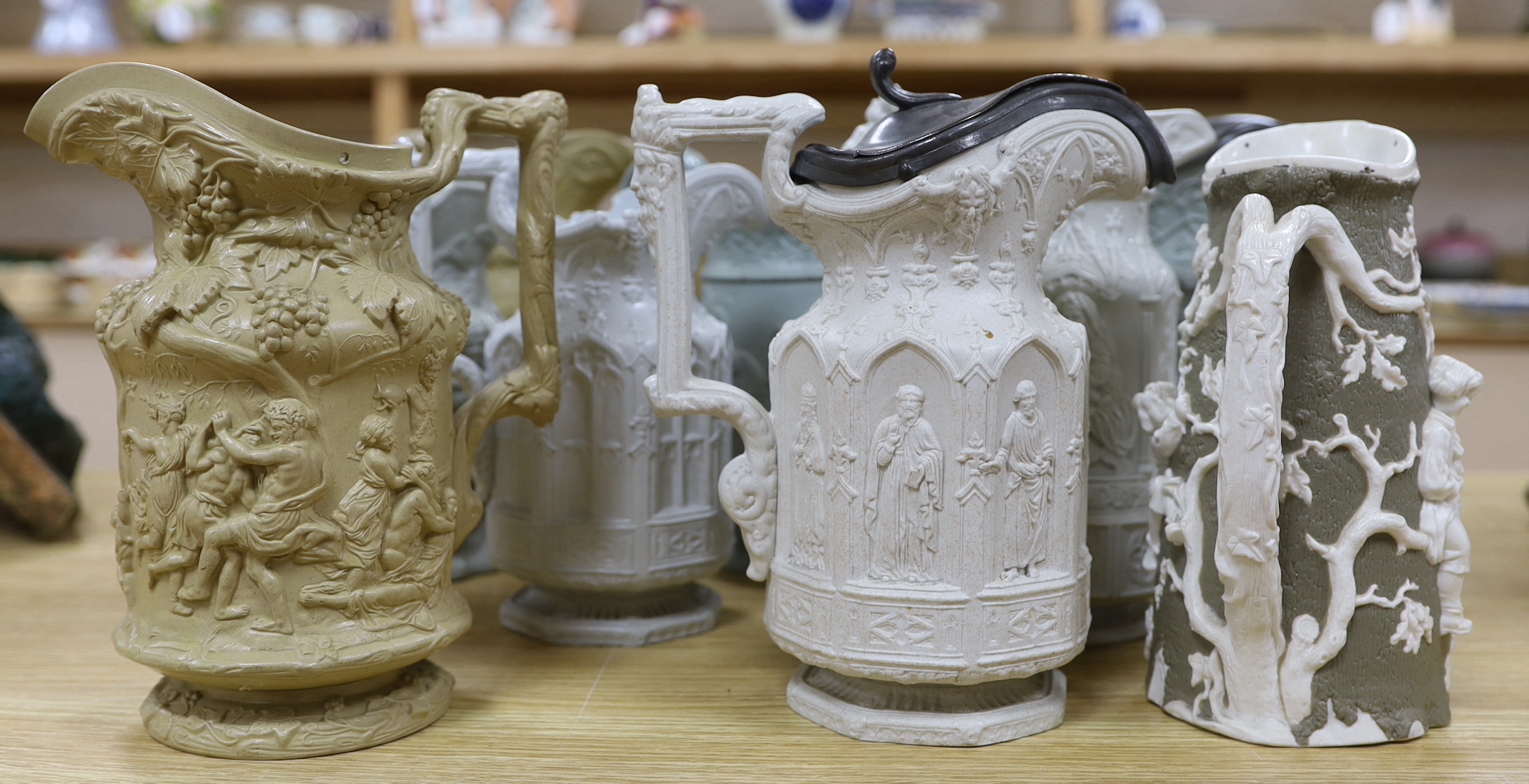 A collection of Victorian Charles Meigh and TJ & JM Mayers stoneware jugs, including Gothic relief designs, some with pewter lids, the largest 23cm high
